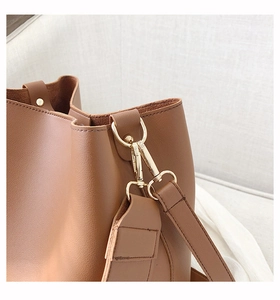 Macro detail of caramel brown leather bag with lychee texture and gold metal hardware