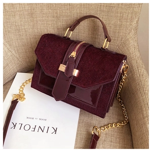 Detail der weinroten Leoparden-Tasche mit glänzendem Lackleder und Metallkettenriemen