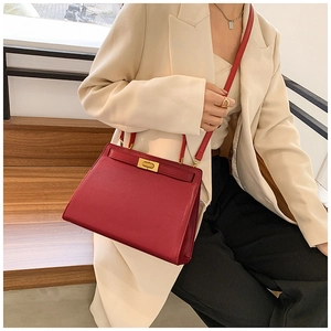 Détail du sac à main en cuir bordeaux avec fermoir doré et bandoulière réglable