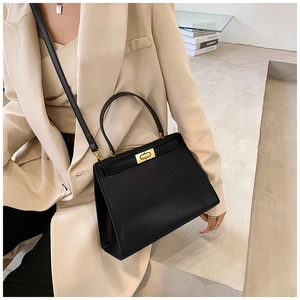 Sac à main structuré noir avec costume beige pour un style professionnel urbain