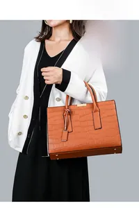 Detail shot of brown crocodile pattern faux leather tote bag with gold-tone hardware
