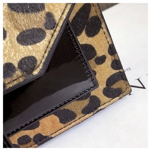 Detailaufnahme von Wildleder mit Leopardenmuster und schwarzem Lackleder mit Nähten