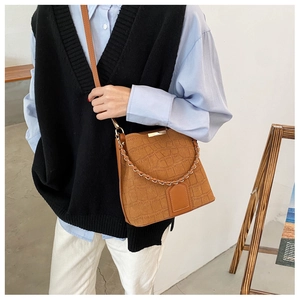 Close-up of retro brown crocodile pattern bucket bag with metal chain and PU texture