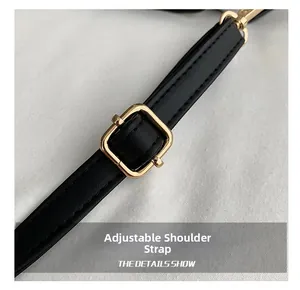 Detail of adjustable black leather shoulder strap with premium golden metal buckle