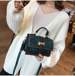Detail of vintage oil wax leather shoulder bag with golden H-lock buckle and retro design