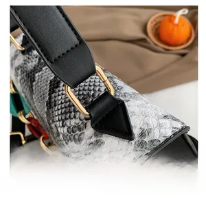 Detailed macro view of snakeskin pattern leather handbag with gold metal hardware buckle