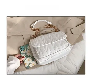 Size comparison of white quilted hobo bag with gold chain strap next to a phone