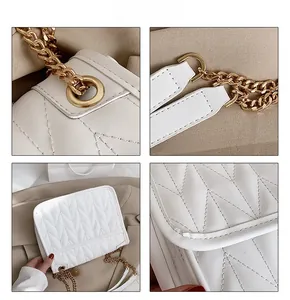 Detailed view of white quilted shoulder bag with V-shaped stitching and gold chain strap