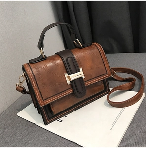 Detail of vintage oil wax leather brown crossbody bag with metal buckle and stitching