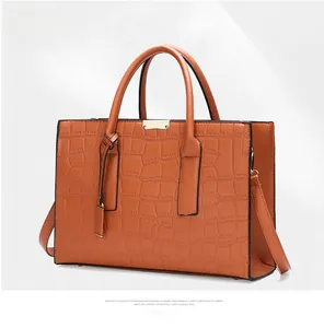 Detail view of brown crocodile texture leather tote with elegant golden hardware