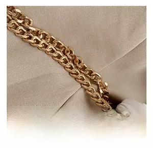 Close-up of premium gold-toned multi-layer chain strap and white quilted leather detail