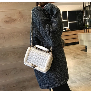 Détail du sac bandoulière en tweed blanc avec perles et chaîne dorée sur maille grise