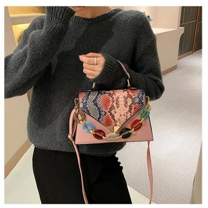 Pink crossbody bag featuring colorful acrylic chain and stylish snakeskin pattern flap