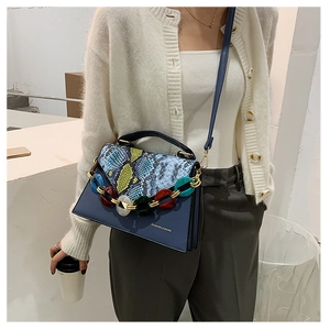 Detail of blue snake print bag with chunky acrylic chain and Fashion & Bags text