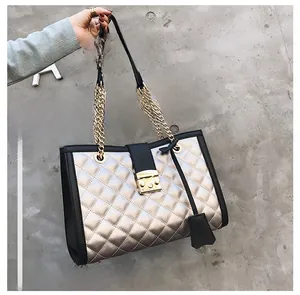 Vue détaillée du sac cabas matelassé doré avec bordure noire et bandoulière chaîne