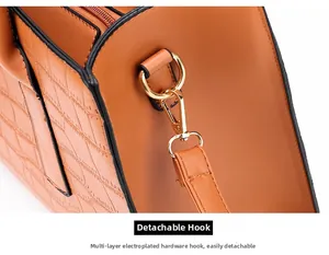Close-up of detachable gold-plated metal hook and crocodile texture on brown handbag