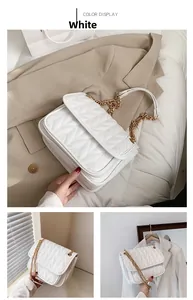Close-up of white quilted leather shoulder bag with V-pattern and gold chain strap