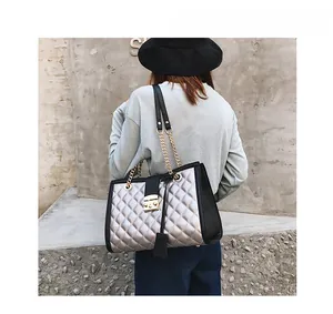 Détail du grand sac cabas argenté matelassé avec fermoir à poussoir doré et chaîne
