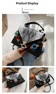Detail of black faux leather bag featuring snake print flap and multi-color resin chain link