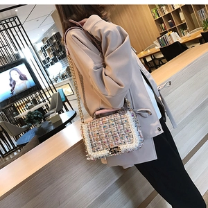 Détail du sac bandoulière en tweed avec perles et chaîne dorée dans un café chic