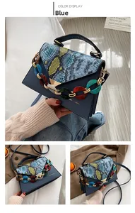 Detail of blue snake print texture flap bag with colorful acrylic chain strap and logo