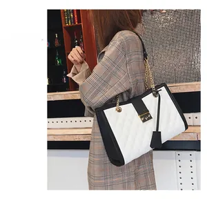 Détail d'un sac chic matelassé avec cuir contrasté noir et blanc et fermoir doré