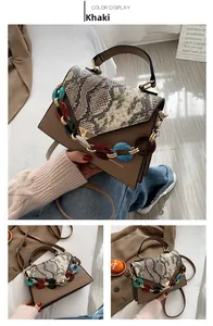 Detail of khaki PU leather handbag featuring snake skin flap and colorful resin chain