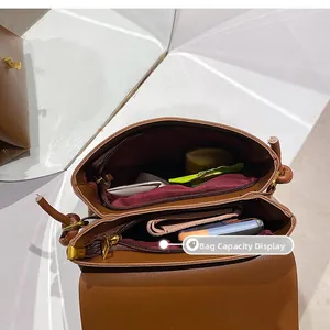 Internal view of brown crossbody bag showing two large zip compartments for essentials