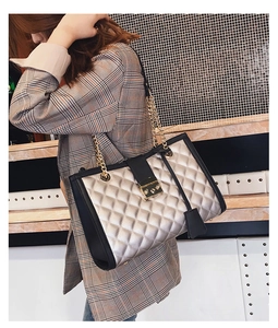 Sac bandoulière matelassé or champagne avec bordure en cuir noir porté par un mannequin