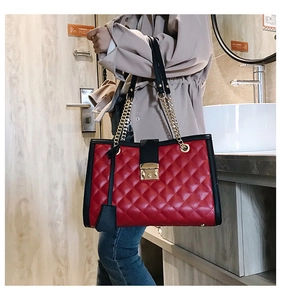 Vue détaillée du sac cabas matelassé rouge et noir avec chaîne dorée et fermoir