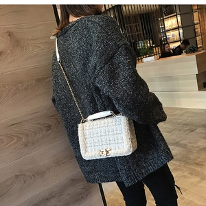 Détail du sac bandoulière en tweed avec bordure en perles et bandoulière chaîne dorée
