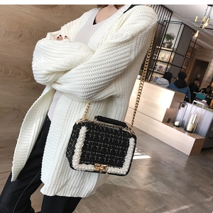 Gros plan sur un sac à bandoulière en tweed noir avec perles et chaîne dorée chic