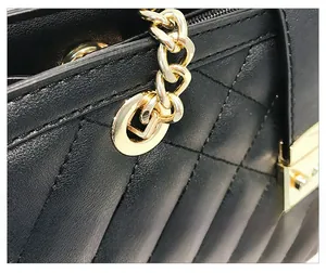 Détails de la ferrure dorée et du motif matelassé sur le sac en cuir noir chic