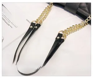 Détail de la bandoulière en chaîne dorée et cuir matelassé noir sur ce sac à bandoulière