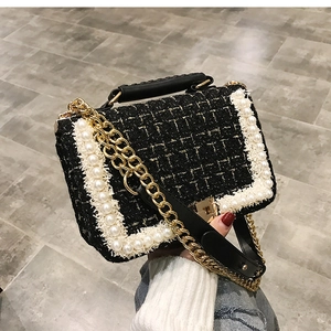 Détail d'un sac bandoulière en tweed noir avec bordure en perles et chaîne dorée chic