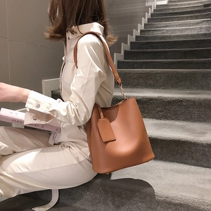 Minimalist brown leather bucket bag for women with shoulder strap and spacious interior