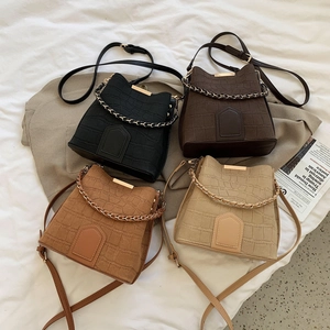 Set of four textured bucket bags in black, coffee, camel and beige with gold chain handles
