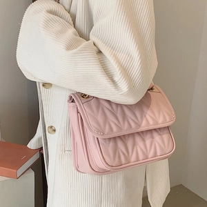 Chic pink quilted shoulder bag with wavy stitching and a golden metal chain strap