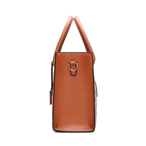 Vintage brown leather handbag with round handle and gold hardware in side view
