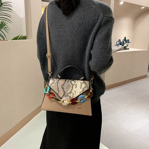 Stylish snake print crossbody bag with resin chain and khaki base shown on model