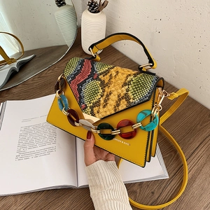 Chic yellow handbag with snake print flap and bold colorful acrylic chain link decoration