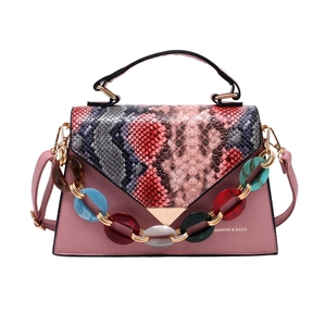 Pink crossbody bag with snakeskin pattern flap and colorful acrylic chain detail