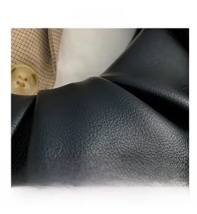 Macro detail of black pleated leather texture and acrylic chain bag craftsmanship