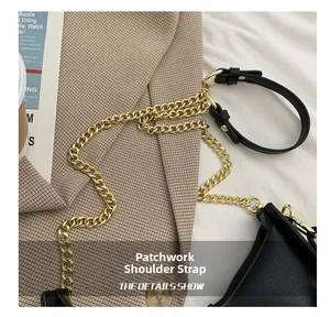 Detail of white cloud bag showing golden metal chain and leather spliced shoulder strap