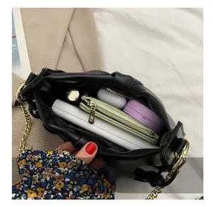 Detail shot of black cloud bag interior with gold chain, showing spacious daily storage