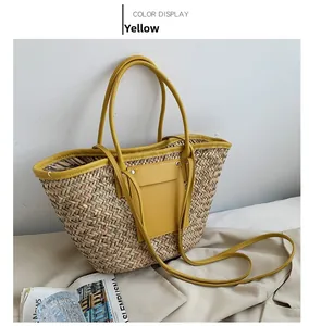 Detail of a yellow woven straw tote bag with leather pocket and long shoulder strap
