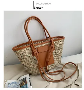 Detail of hand-woven straw tote bag with brown leather pocket and long shoulder straps