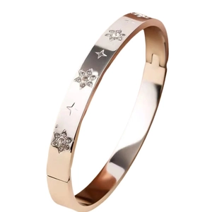 Detailed close-up of rose gold stainless steel bangle with inlaid zircon stars and cross motifs
