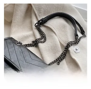 Détail du fermoir tournant vintage et du cuir matelassé chevron sur sac bandoulière noir