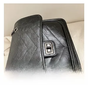 Close-up of black chevron quilted handbag with metallic twist lock and chain strap